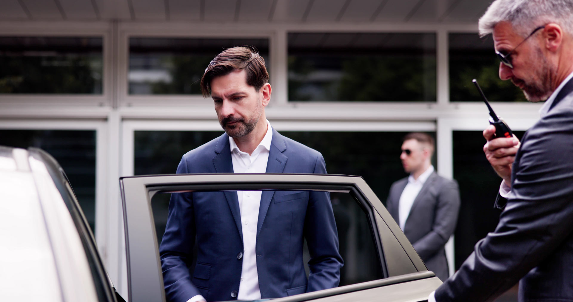 Personenschützer begleitet einen Mann zu einem Fahrzeug